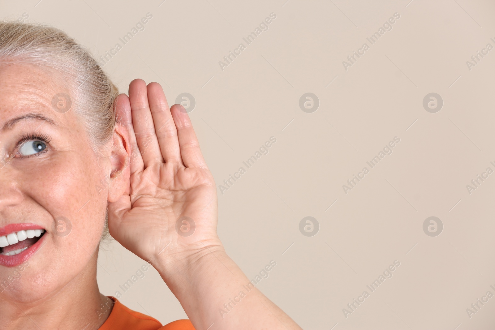 Photo of Mature woman with hearing problem on light background, closeup. Space for text