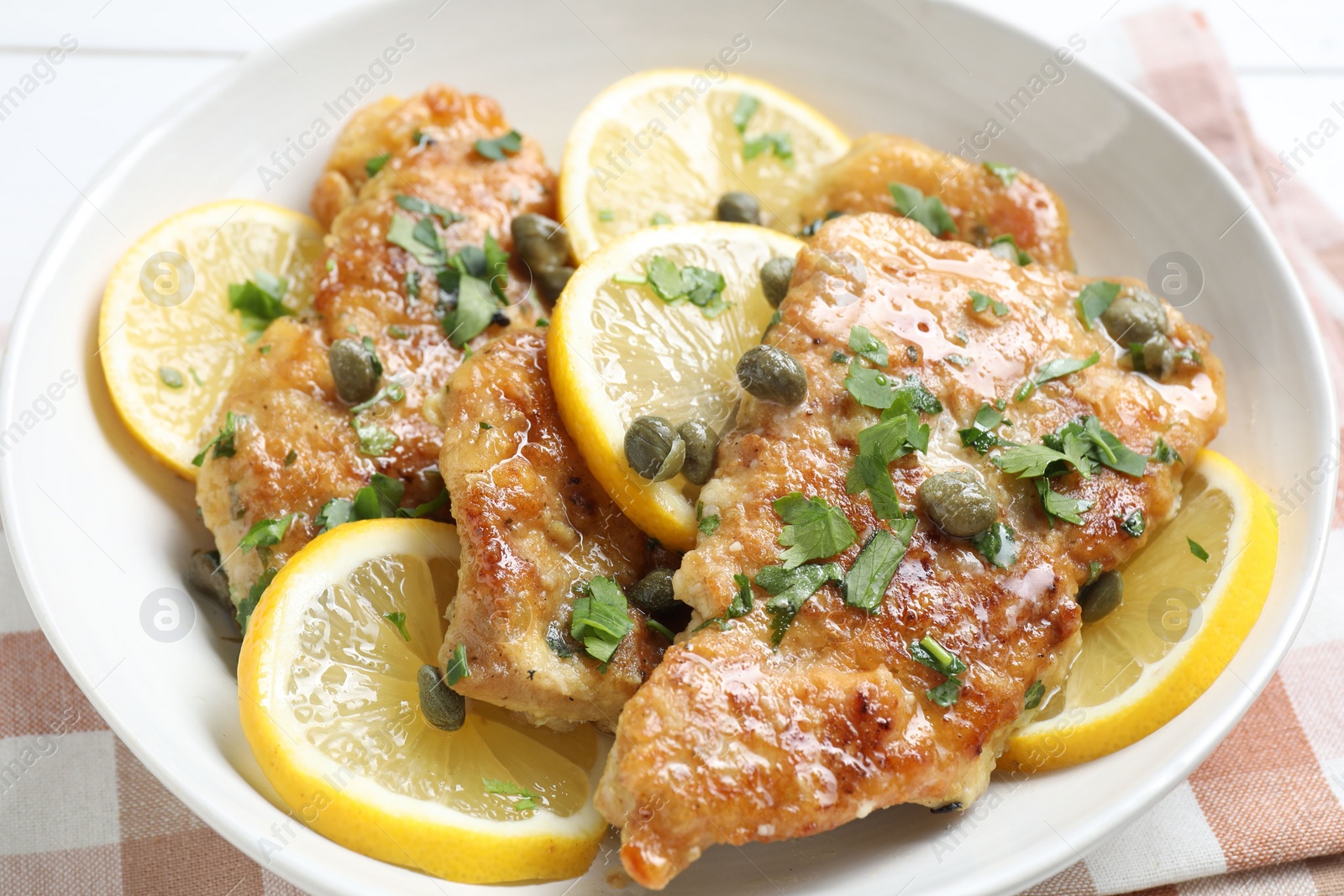 Photo of Delicious chicken piccata with herbs on table, closeup