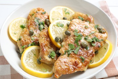 Delicious chicken piccata with herbs on table, closeup