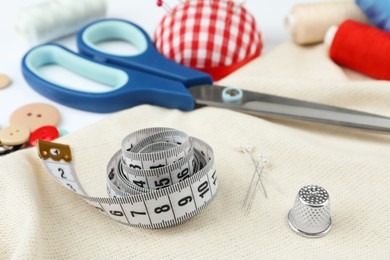 Photo of Different sewing accessories on white background, closeup
