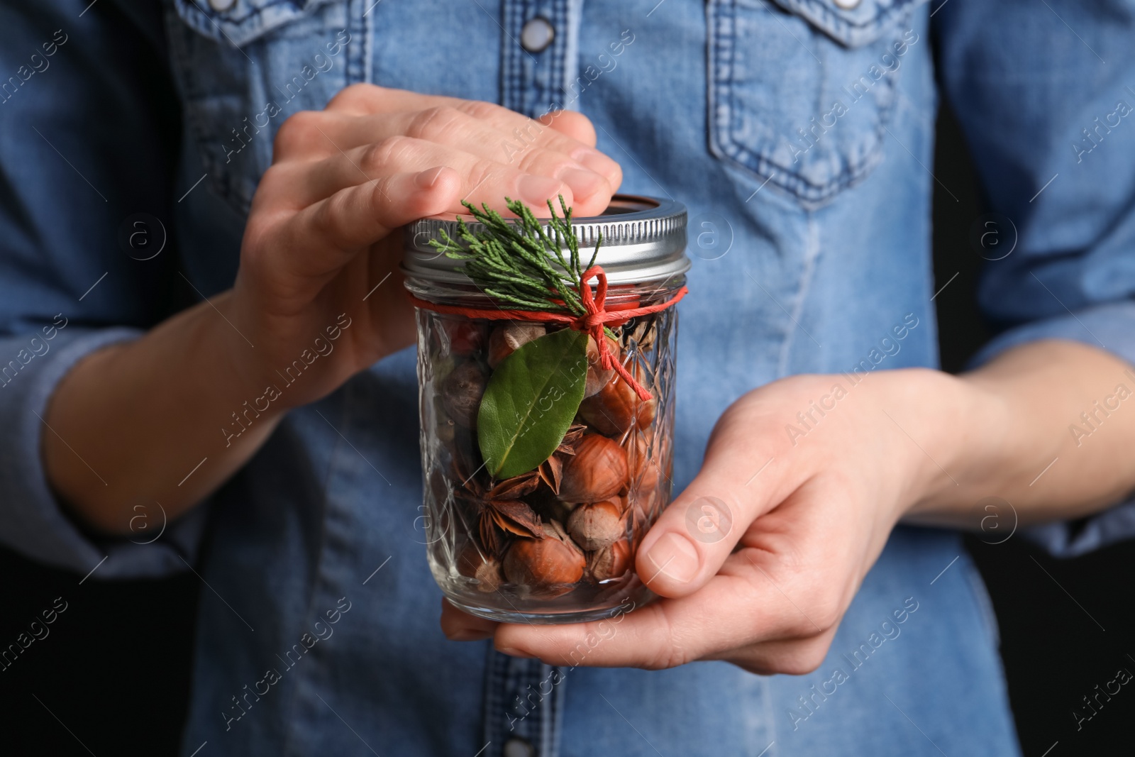 Photo of Woman holding jar with aromatic potpourri, closeup