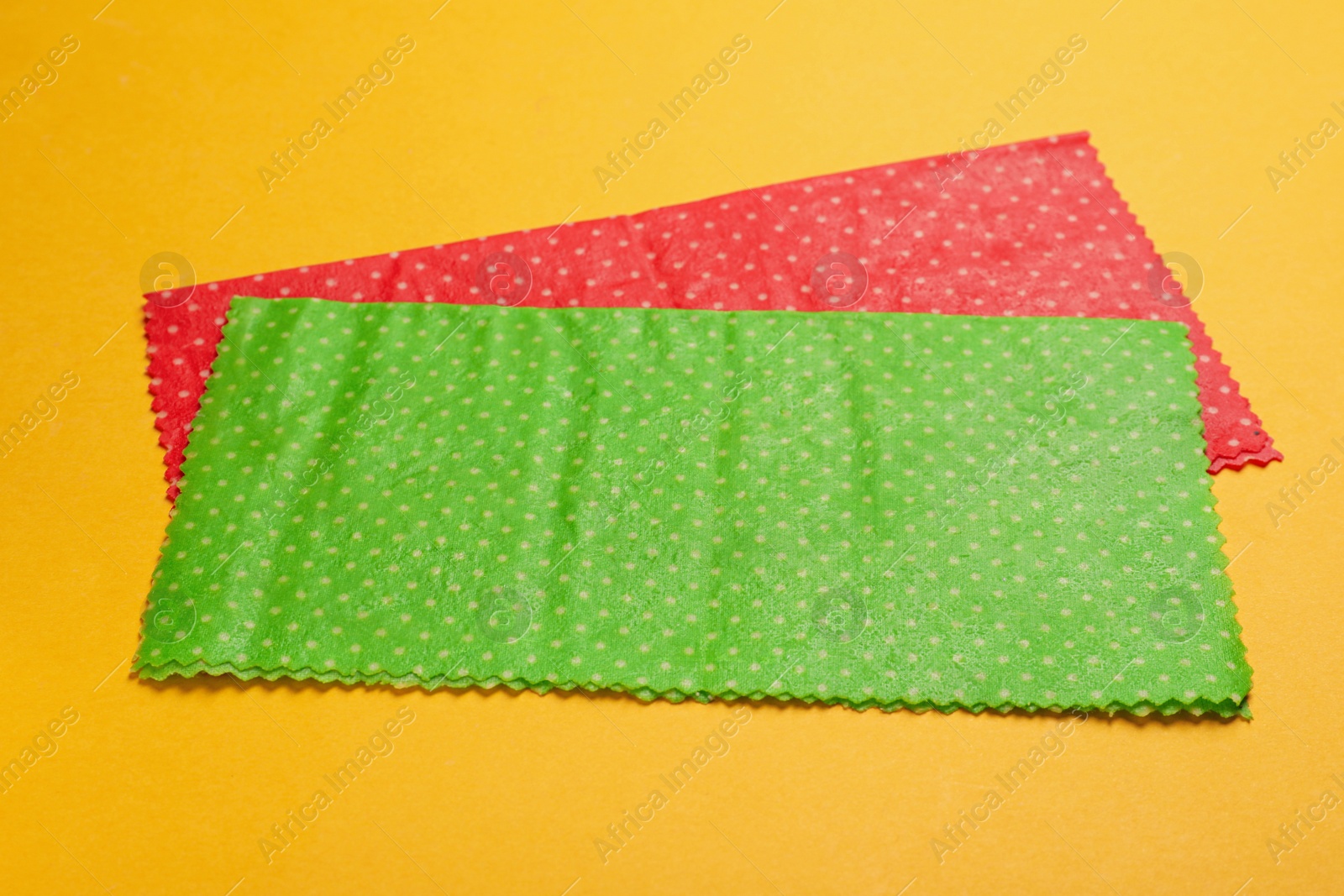 Photo of Reusable beeswax food wraps on yellow background