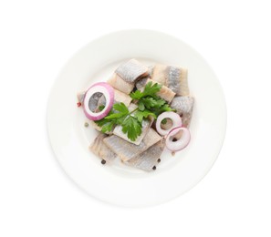 Plate with delicious salted herring slices, onion rings, peppercorns and parsley isolated on white, top view
