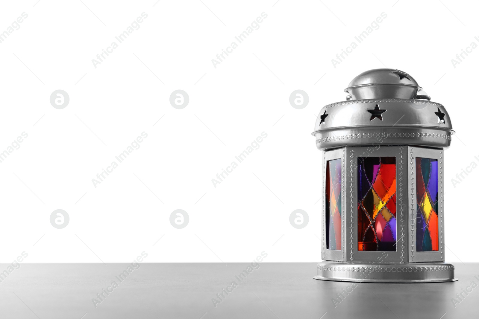 Photo of Decorative Arabic lantern on grey table against white background