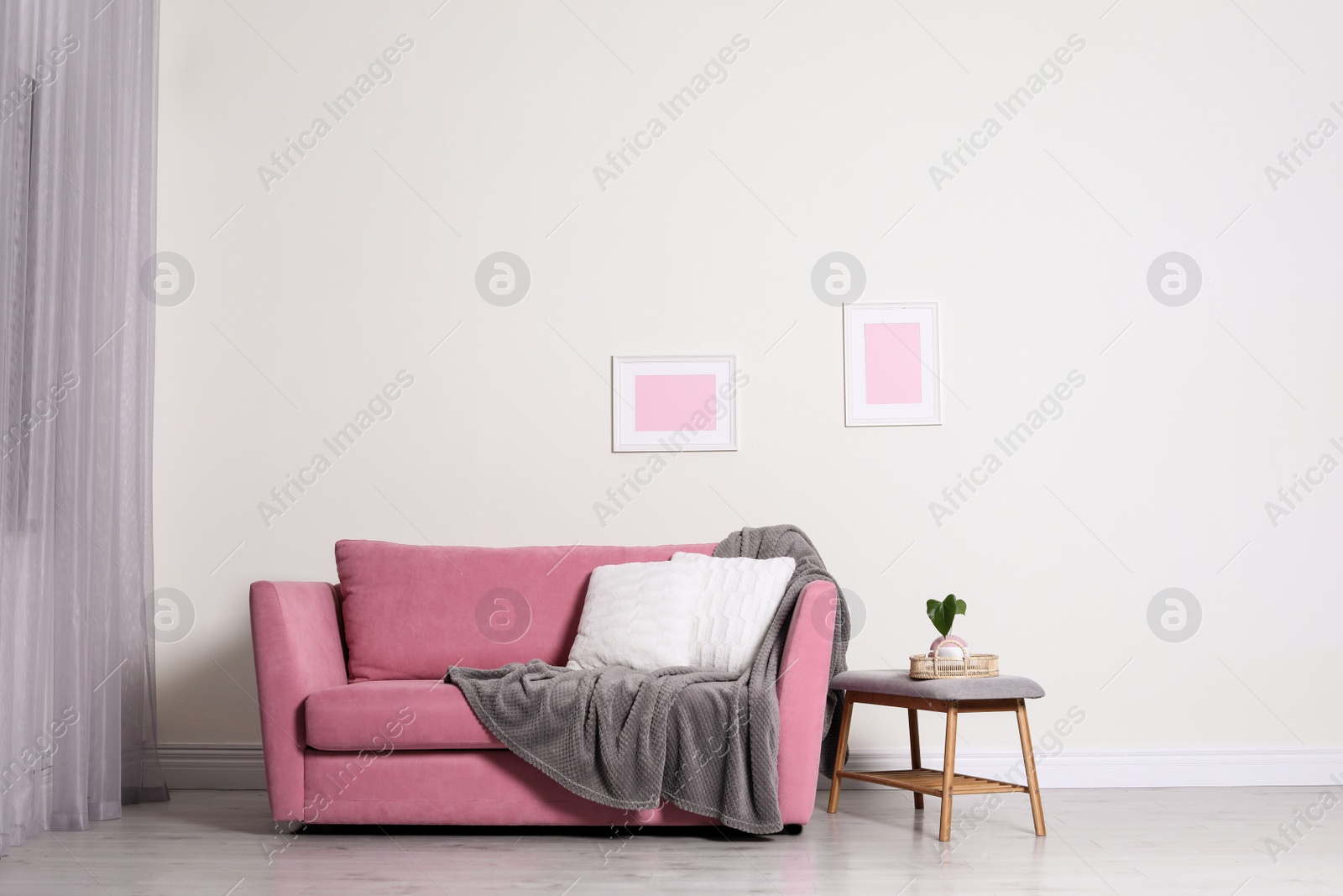 Photo of Cozy living room interior with sofa, pillow and plaid near light wall. Space for text