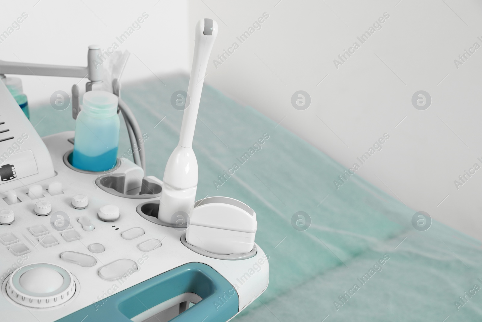 Photo of Ultrasound control panel and examination table in hospital, closeup. Space for text