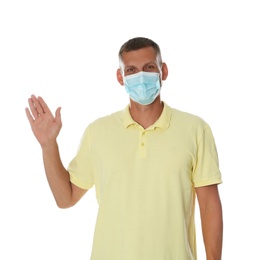 Photo of Man in protective mask showing hello gesture on white background. Keeping social distance during coronavirus pandemic