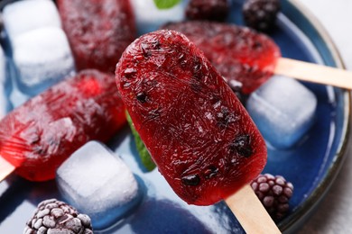 Photo of Tasty blackberry ice pops, closeup. Fruit popsicle