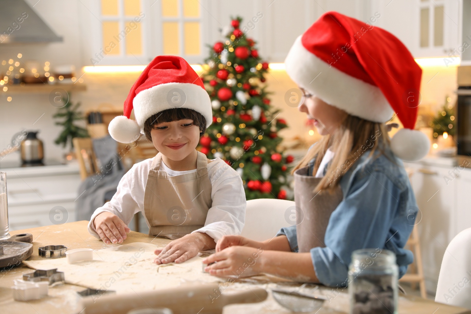 Photo of Cute little children making Christmas cookies in kitchen