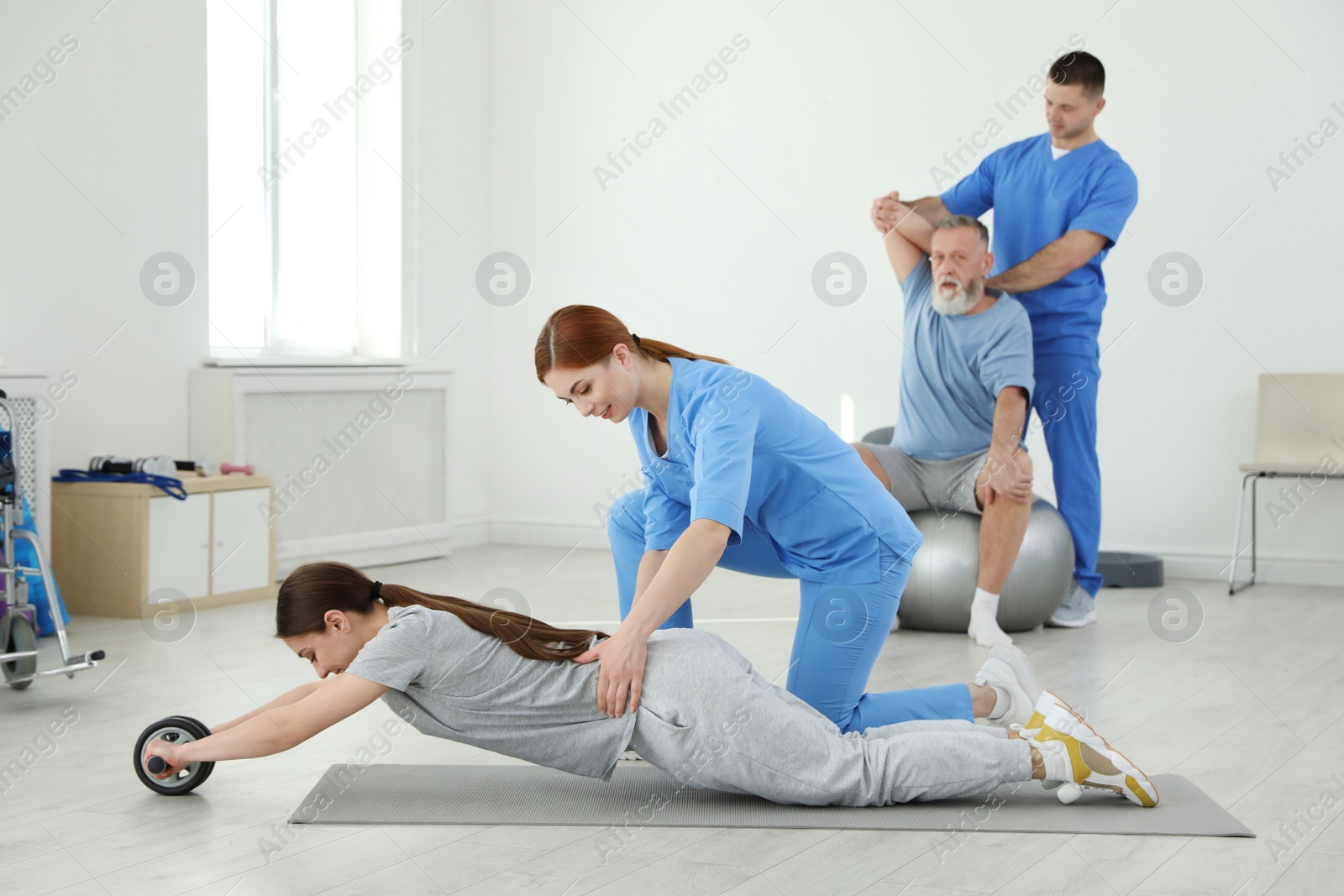 Photo of Professional physiotherapists working with patients in rehabilitation center