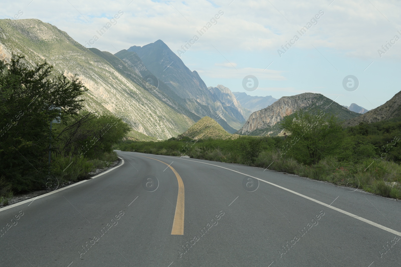 Photo of Beautiful view of empty asphalt highway near mountains outdoors. Road trip