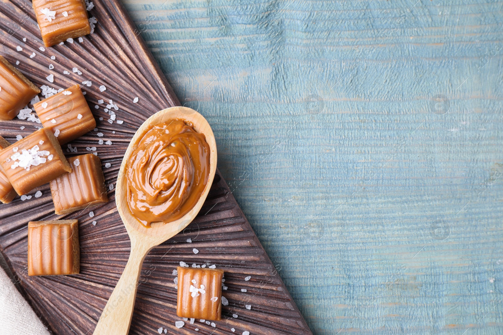 Photo of Salted caramel on blue wooden table, top view. Space for text
