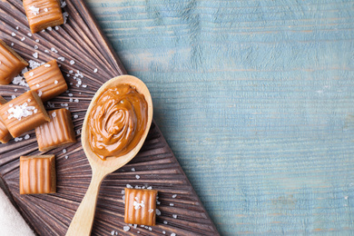 Photo of Salted caramel on blue wooden table, top view. Space for text