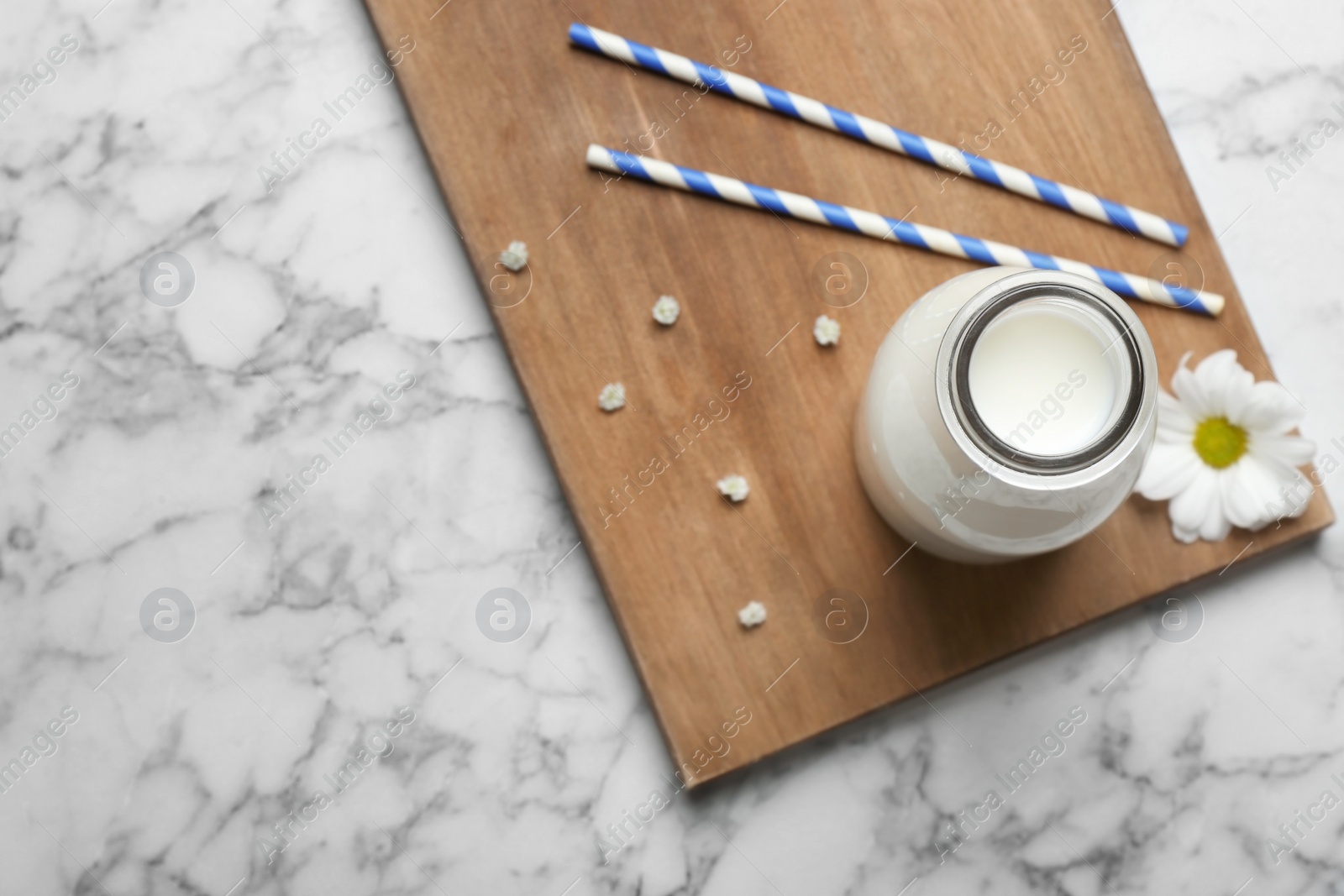 Photo of Bottle of milk and straws on light background, top view