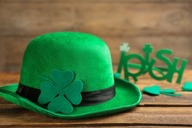 Photo of Leprechaun hat, decorative clover leaf and party glasses on wooden background. St Patrick's Day celebration