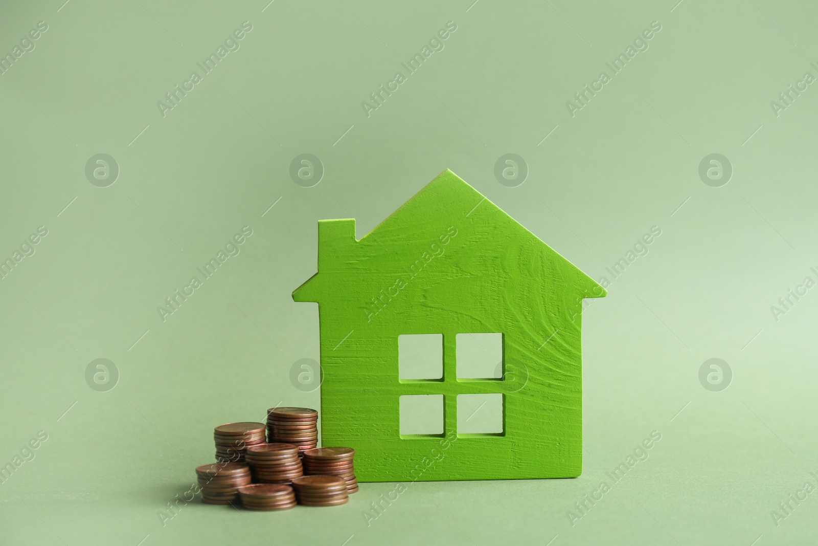 Photo of House model and coins on color background. Space for text