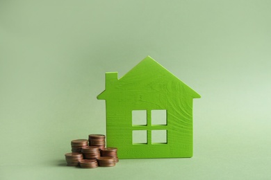 Photo of House model and coins on color background. Space for text