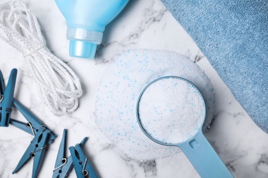 Flat lay composition with laundry detergents, clothespins and towel on marble background