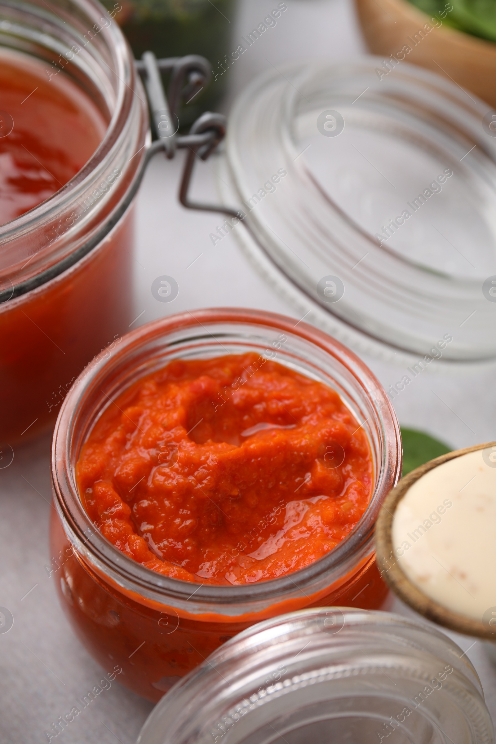 Photo of Fresh homemade marinade in jar on table, closeup