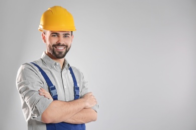 Photo of Portrait of professional construction worker in uniform on grey background, space for text