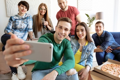 Photo of Happy friends taking selfie indoors