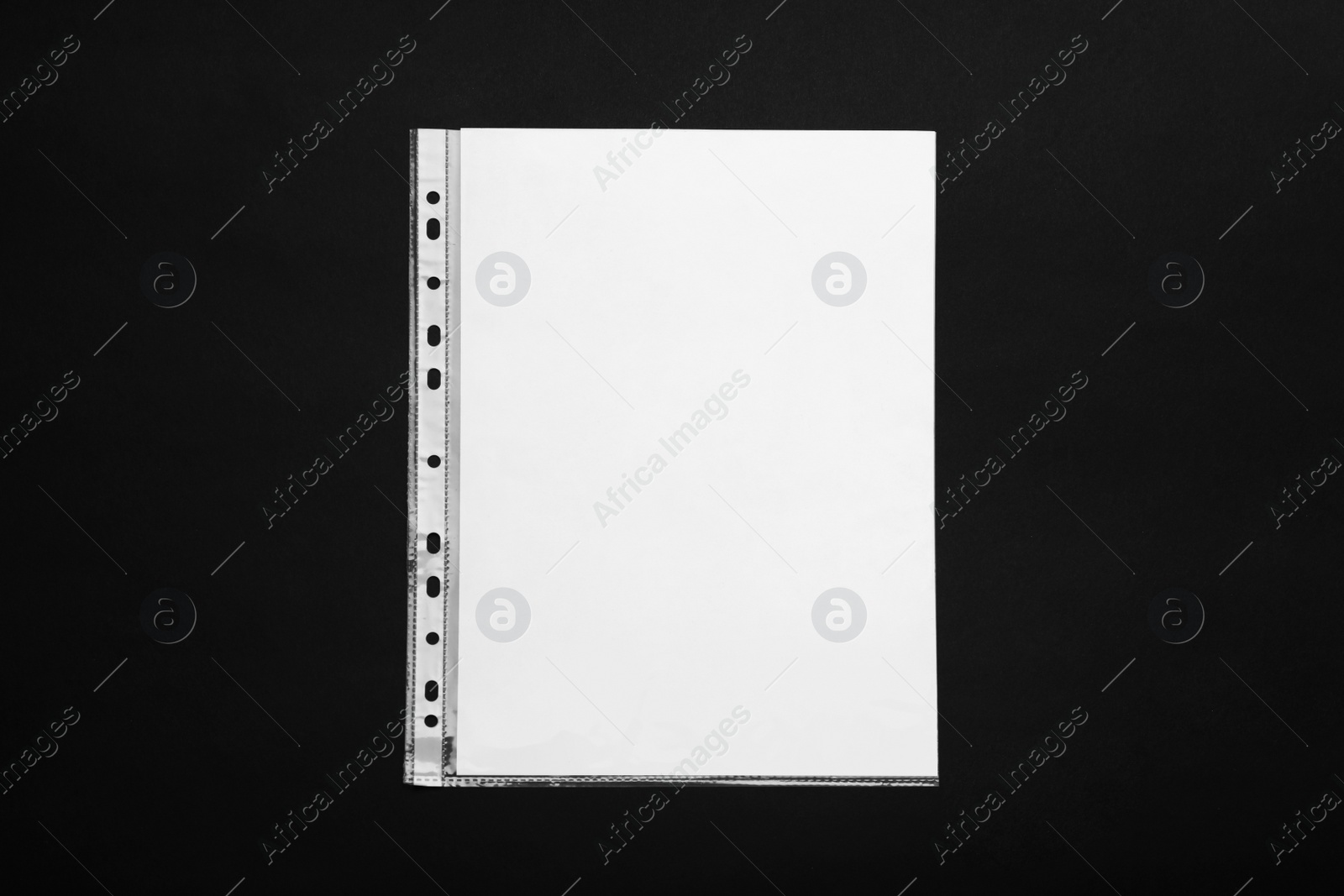 Photo of Punched pocket with paper sheet on black background, top view