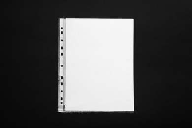 Punched pocket with paper sheet on black background, top view