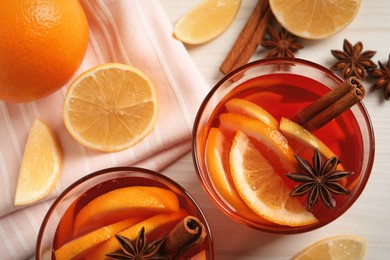 Photo of Aromatic punch drink and ingredients on white wooden table, flat lay