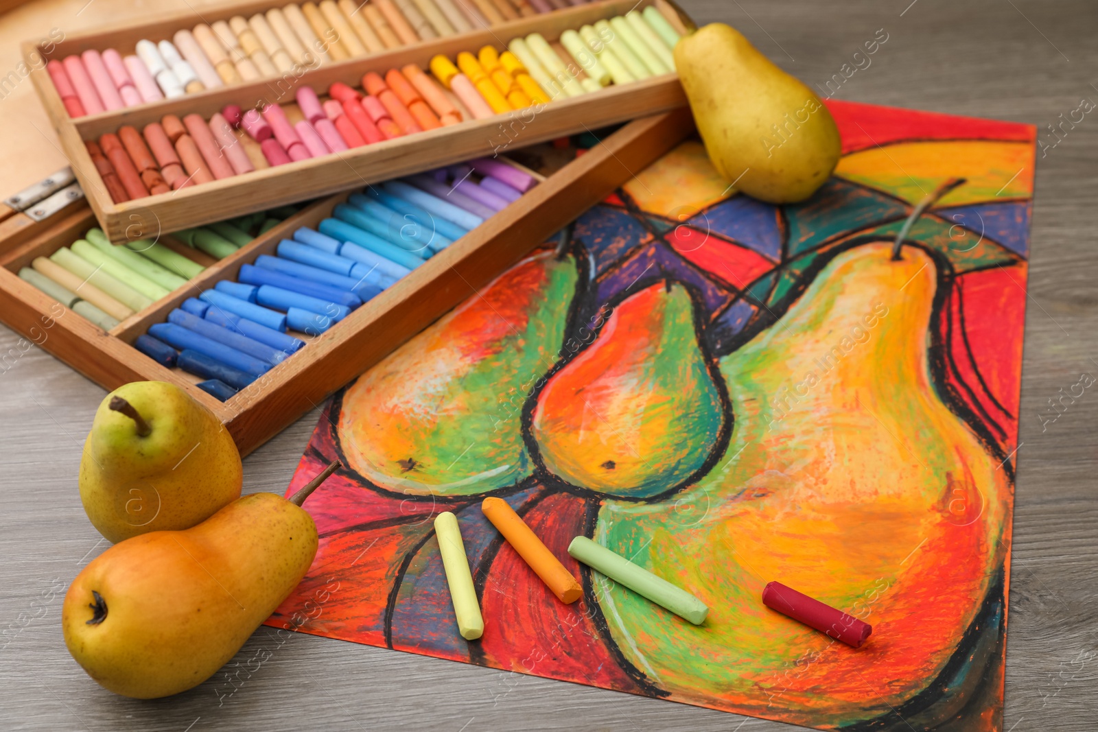 Photo of Beautiful drawing of pears, fresh fruits and colorful pastels on wooden table