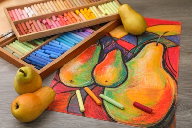 Photo of Beautiful drawing of pears, fresh fruits and colorful pastels on wooden table