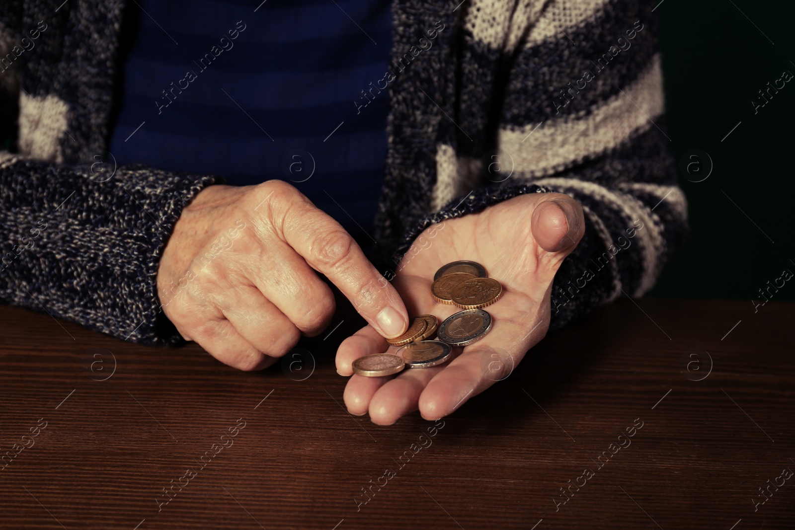 Photo of Poor senior woman with coins at table, closeup