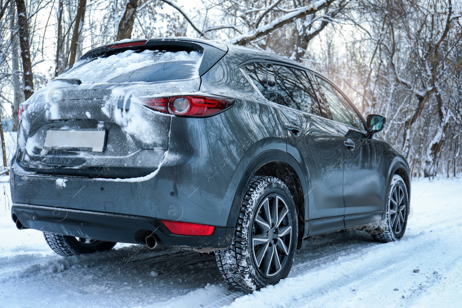 Photo of Snowy country road with car on winter day