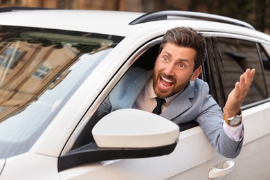 Photo of Angry driver screaming at someone from car in traffic jam