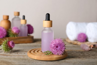 Photo of Bottles of herbal essential oil and flowers on wooden table