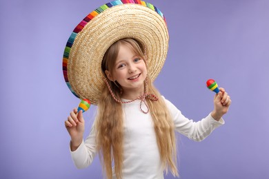 Cute girl in Mexican sombrero hat dancing with maracas on purple background