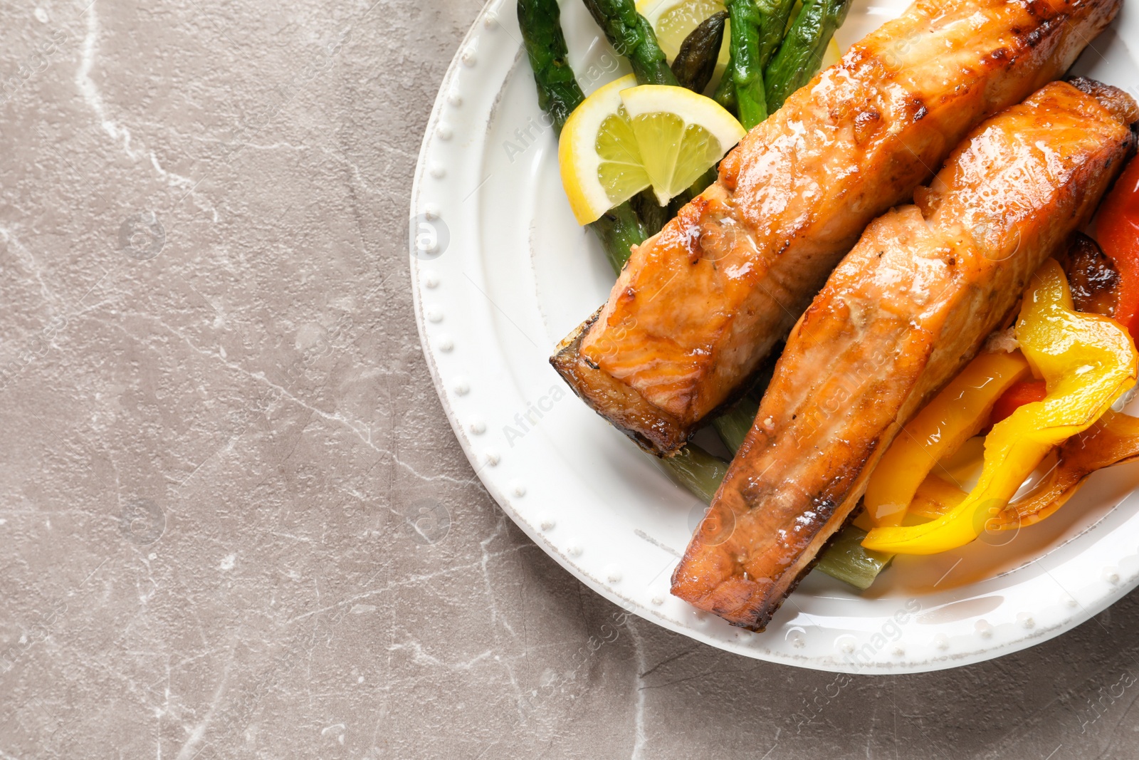 Photo of Tasty cooked salmon with vegetables on plate