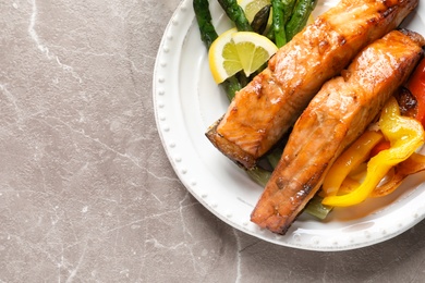 Tasty cooked salmon with vegetables on plate