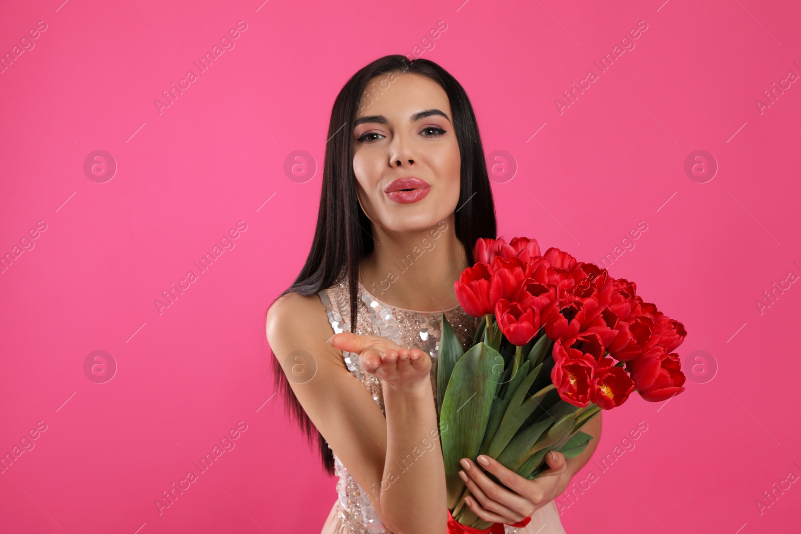 Photo of Happy woman with red tulip bouquet on pink background. 8th of March celebration