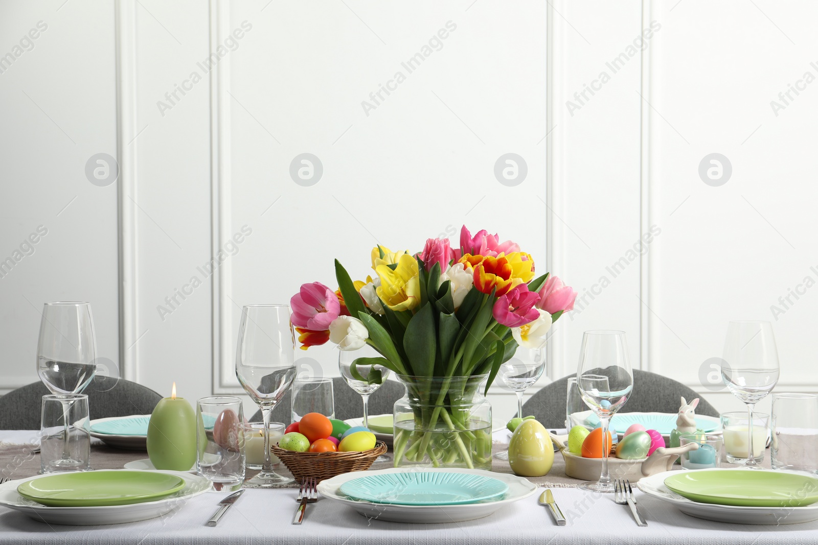 Photo of Easter celebration. Festive table setting with beautiful flowers and painted eggs