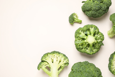 Photo of Fresh tasty broccoli on light beige background, flat lay. Space for text