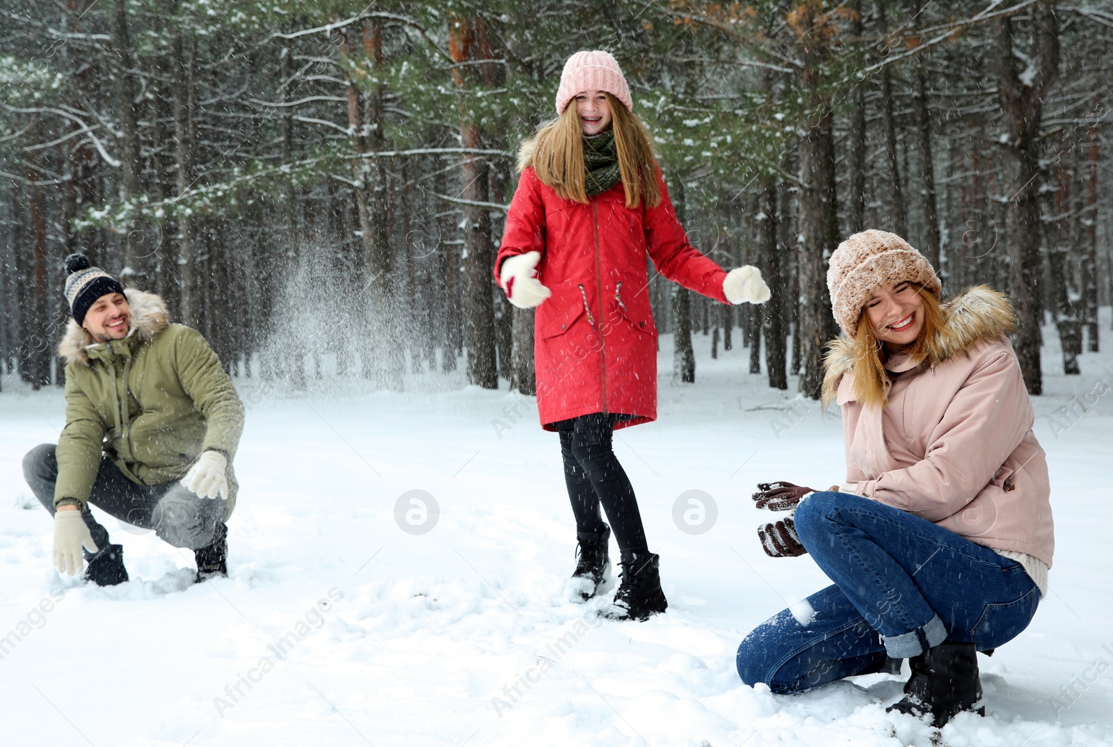 Photo of Happy family playing snowballs in winter forest