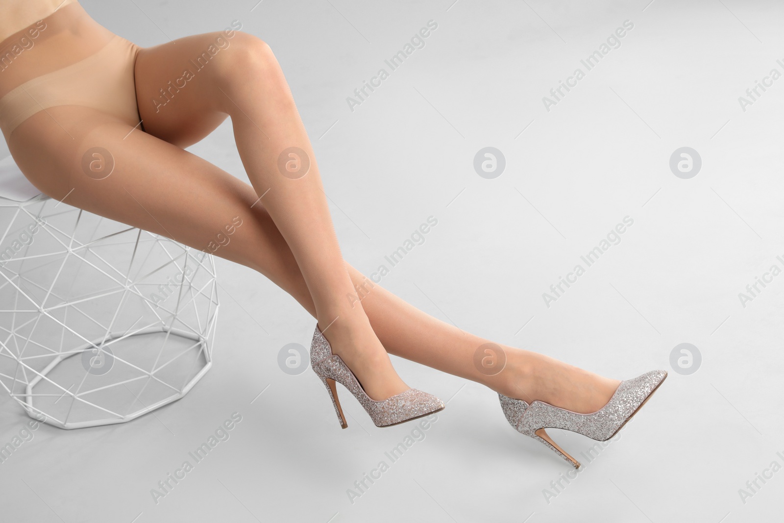 Photo of Woman wearing tights and stylish shoes on light grey background, closeup of legs