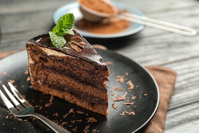 Photo of Plate with slice of chocolate cake and fork on table