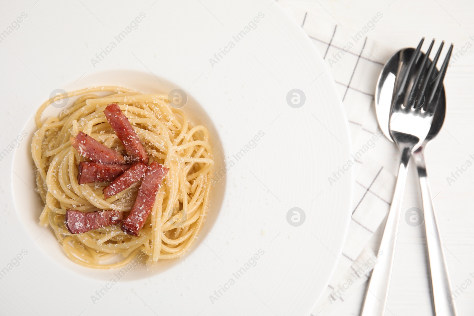 Photo of Delicious Carbonara pasta served on white wooden table, flat lay