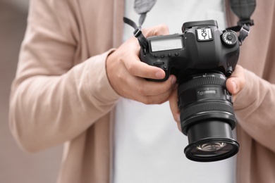 Photo of Male photographer with professional camera, closeup view