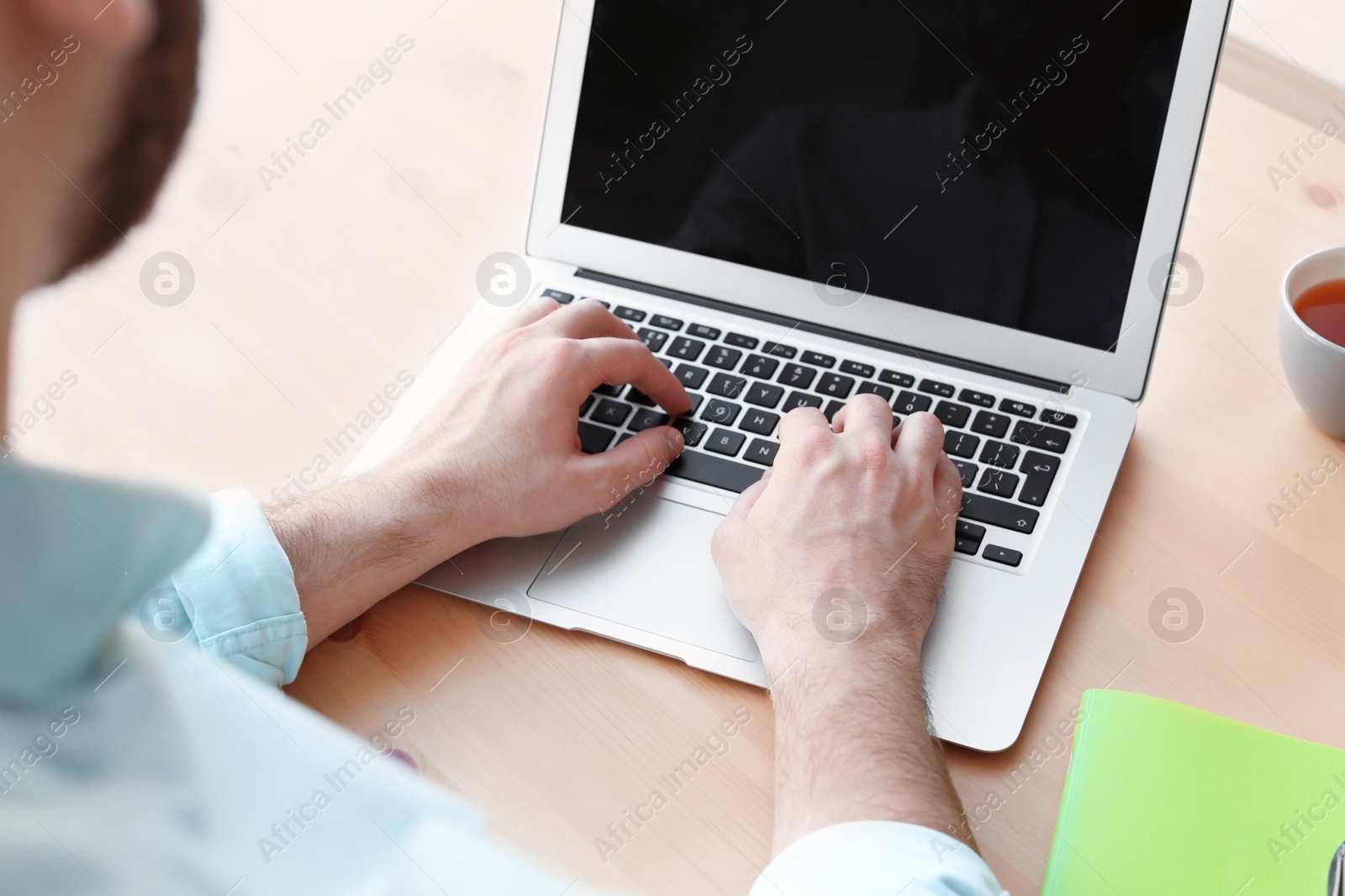 Photo of Young man working with laptop at desk. Home office