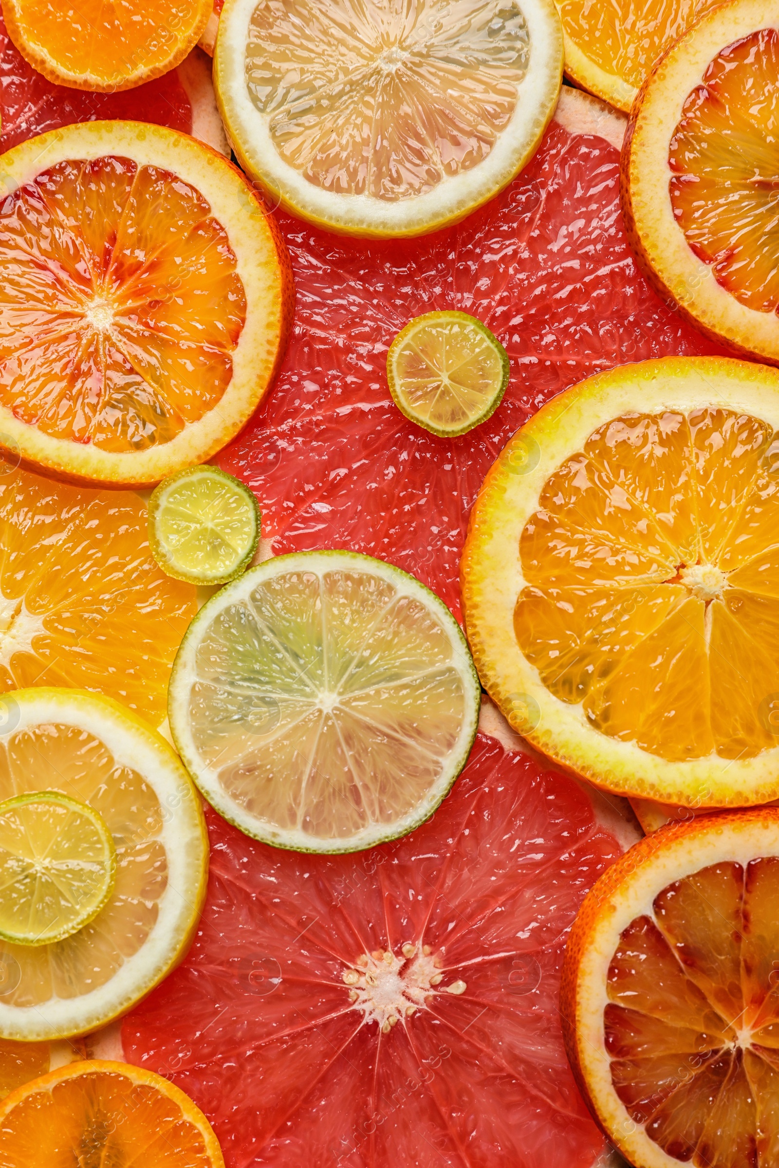 Photo of Slices of fresh citrus fruits as background, top view