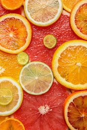 Photo of Slices of fresh citrus fruits as background, top view