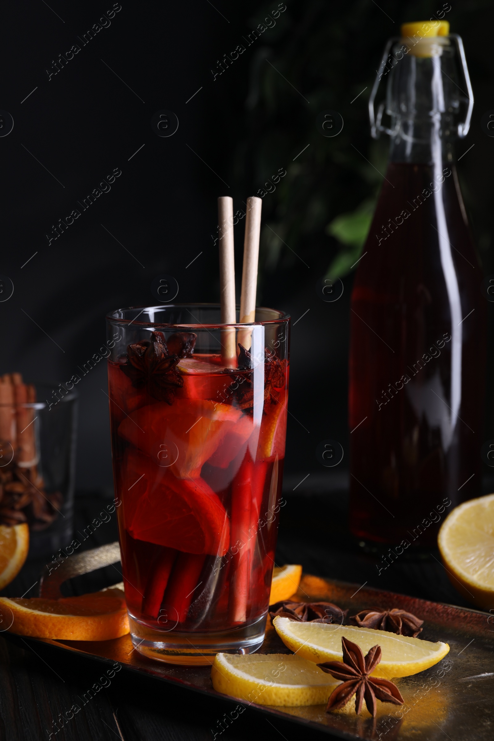 Photo of Glass of aromatic punch drink and ingredients on table