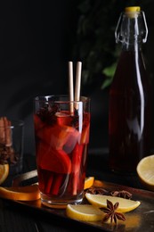 Photo of Glass of aromatic punch drink and ingredients on table